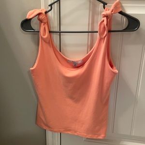 Peach colored tank top that ties on the shoulder.